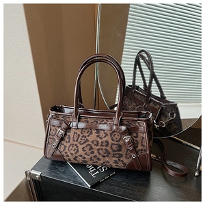 Detail der Vintage-Tasche mit Leopardenmuster, dunkelbraunen Lederriemen und Metallschnallen