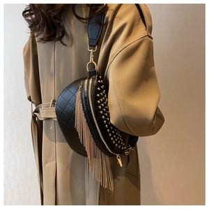 Détail du sac bandoulière noir matelassé avec rivets dorés et franges en métal