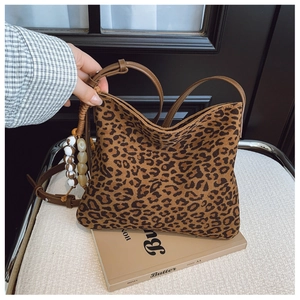 Dettaglio della borsa leopardata con tracolla in pelle e ciondolo decorativo in perline