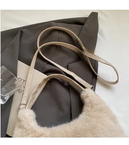 Dettaglio della borsa in morbido peluche con tracolla lunga in pelle liscia beige