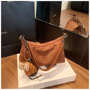 Brown faux suede crossbody pillow bag with plush bear charm and silver metal hooks