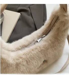 Dettaglio di una borsa in peluche beige con cerniera in metallo argentato a scorrimento