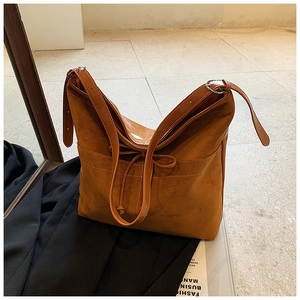 Détail du sac cabas en daim rétro avec bordure en cuir et nœud de décoration