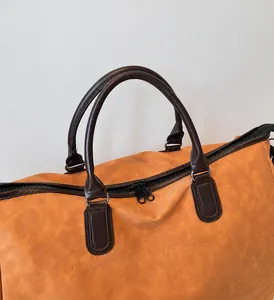 Détail des poignées en cuir PU marron et double fermeture éclair métallique du sac