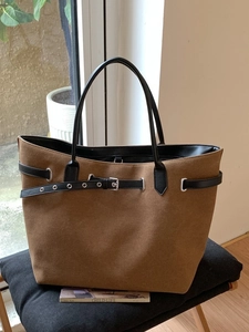 Braune Wildleder-Einkaufstasche mit schwarzen Riemen und Schnalle auf Hocker