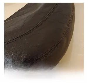 Macro shot of high-quality brown leather bag showing precise double-stitch craftsmanship