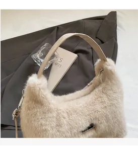 Dettaglio borsa a mano in peluche beige con robusti manici in pelle e finiture in metallo