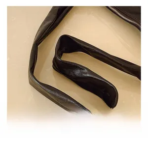 Close-up of the black leather shoulder strap showing soft texture and premium metal zipper