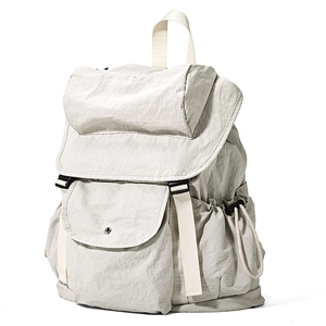 Vista laterale di uno zaino in nylon grigio chiaro con dettagli di tasche e texture