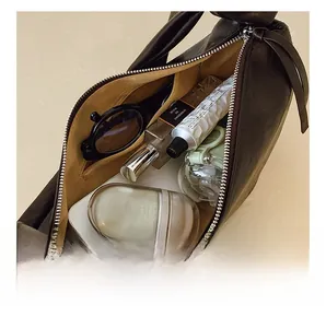 Detailed interior view of a dark brown leather dumpling bag with items showing large capacity