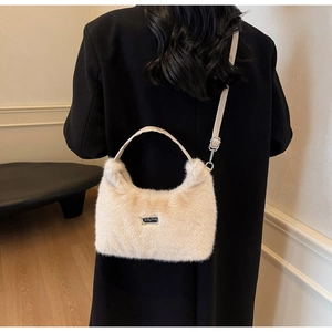 Dettaglio della morbida pelliccia sintetica e del logo JINGPIN sulla borsa beige pelosa
