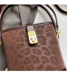 Close-up of matte leopard print bucket bag featuring a premium gold metal twist lock