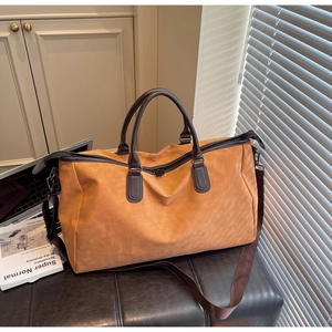 Gros plan détaillé d'un grand sac de voyage marron caramel avec poignées en cuir