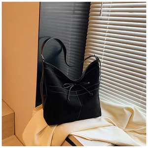 Détail du grand sac cabas noir en suède avec surpiqûres contrastées et nœud décoratif
