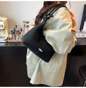 Chic black matte shoulder bag featuring silver oval metal buckle and unique knot shoulder strap