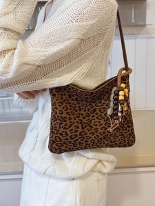 Elegante borsa a spalla leopardata con nappa di perline vintage su maglione crema