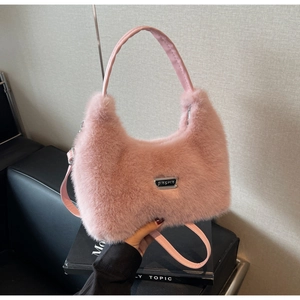 Dettaglio borsa in pelliccia sintetica rosa con logo metallico JINGPIN e manici in pelle
