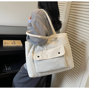 Detailansicht der cremefarbenen Stepptasche mit Vordertasche und weicher Polsterung