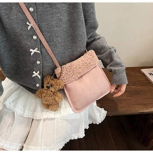 Dettaglio della borsa a tracolla in lana di agnello rosa con un orsetto di peluche