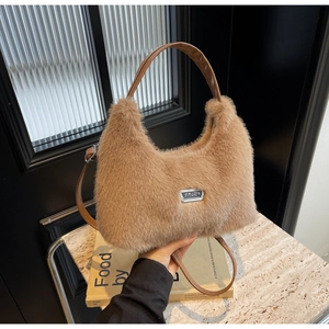 Dettaglio della borsa hobo in ecopelliccia marrone con manico in pelle e logo in metallo