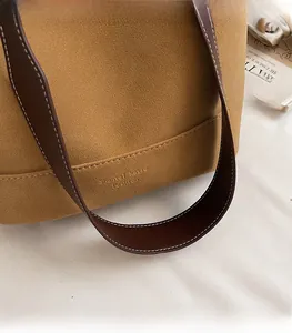 Gros plan détaillé du sac seau en cuir givré marron avec surpiqûres contrastées