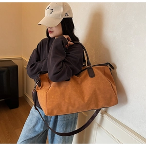 Détail du sac fourre-tout marron-orange vintage avec poignées et bandoulière réglable