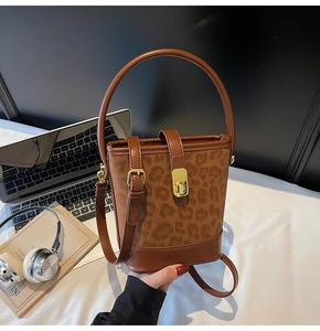 Detail of vintage leopard print bucket bag with gold buckle and brown leather handle