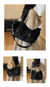 Detail of black canvas tote bag showing adjustable metal buckle and side pocket design
