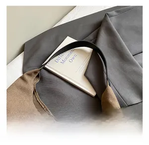 Detail showing the brown canvas crescent bag with a comfortable black leather strap