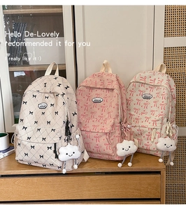 Detail of corduroy backpacks with bow patterns and cloud plush charms in various colors