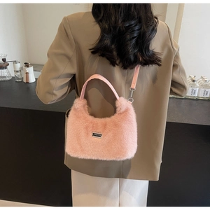 Borsa rosa in ecopelliccia con manici in pelle in un ambiente di caffè