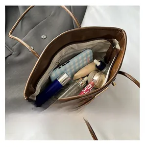 Top view of large leopard print tote bag interior with smartphone and makeup