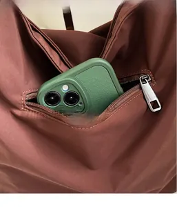 Detail of hidden zipper pocket on brown canvas tote bag for secure smartphone storage