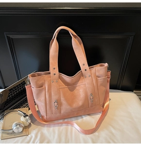 Macro detail of soft peach tote bag with adjustable nylon strap and metal hardware