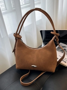 Chic brown soft leather shoulder bag with vintage round silhouette and knotted strap