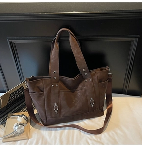 Detailed macro view of dark brown retro tote bag with suede texture and metal rivet accents