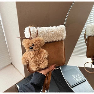 Dettaglio borsa a secchiello in peluche, texture in pelle scamosciata marrone e orsetto