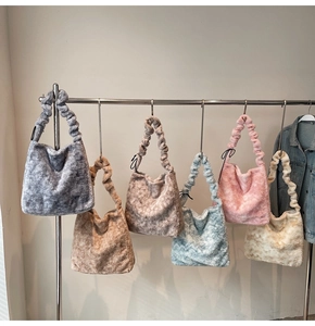 Detail showing plush shoulder bags in various colors with pleated handle design