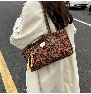Leopard print tote bag with brown leather trim and colorful wooden bead tassel charm