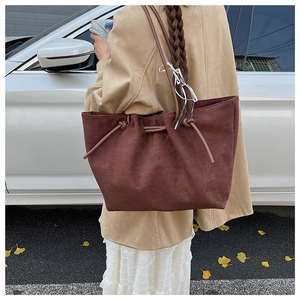 Deep brown oversized suede tote bag shown on shoulder for daily commute style