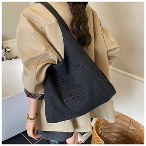 Detail of OZBG black canvas tote bag showing the letter embroidery and spacious interior