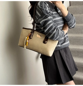Detail of canvas leopard tote with leather handles and decorative wooden bead charm