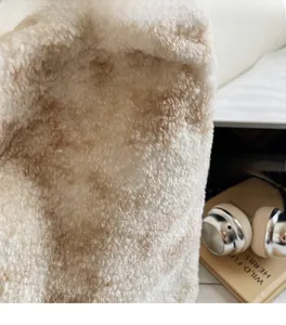 Close-up of soft plush faux fur texture on a cream shoulder bag with cozy fleece detail