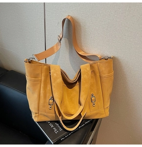Detail of dark ginger yellow suede tote bag with metal buckle and adjustable strap