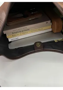 Interior view of brown leather tote bag showing large capacity for laptop and books