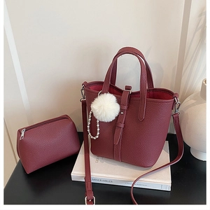 Dettaglio della borsa a secchiello bordeaux in pelle martellata con mini pochette