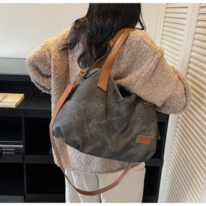 Detail of stone-washed canvas tote with brown straps and adjustable shoulder strap