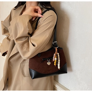 Detail of vintage leopard tote with heart charm and beaded pendant on suede strap