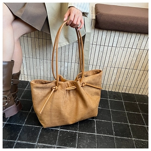 Top view of brown suede tote bag featuring decorative drawstring ties and rope handles