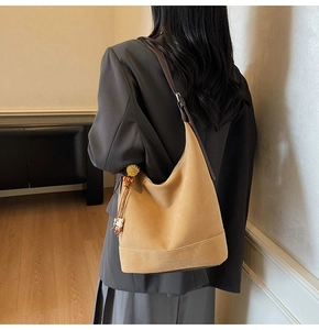 Détail du sac hobo en daim kaki avec des franges et une fine bandoulière marron